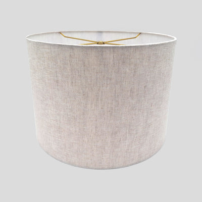 The Linen Short Drum (Rolled Edges) is a simple cylindrical lampshade with a subtle linen texture and exposed wire frame at the top, shown against a light gray background.
