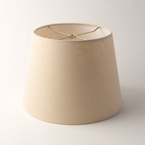A tan linen British Empire lampshade with rolled edges and translucent finish, shown against a plain white background.
