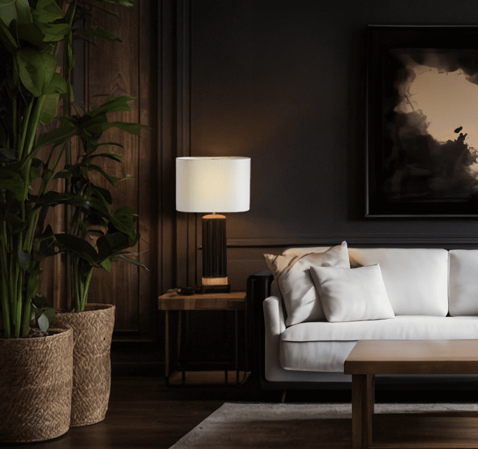 A living room with a white couch and a painting, illuminated by oval lamp shade.