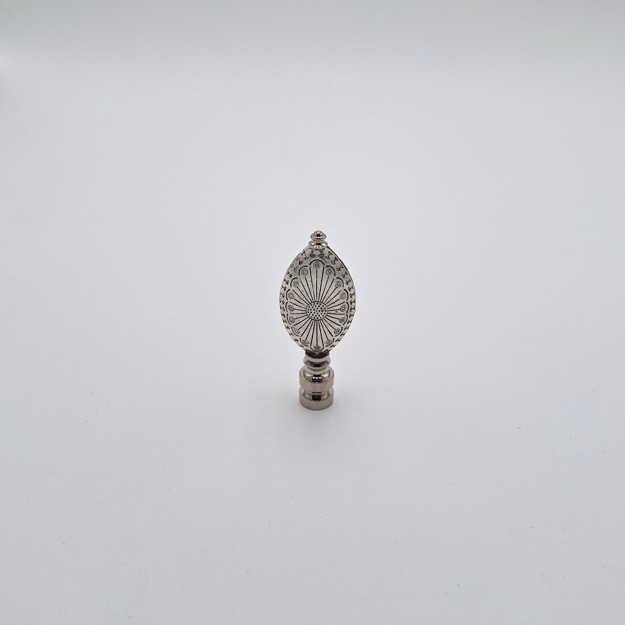 An engraved oval finial with an antiqued nickel finish and detailed engraved patterns, shown against a plain white background.