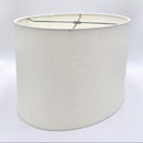 A tapered bone linen oval lampshade with rolled edges and nickel silver spider hardware, shown against a plain white background.
