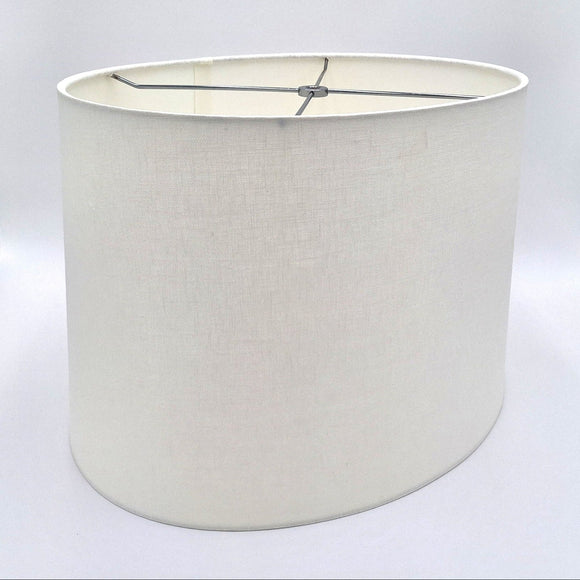 A tapered bone linen oval lampshade with rolled edges and nickel silver spider hardware, shown against a plain white background.