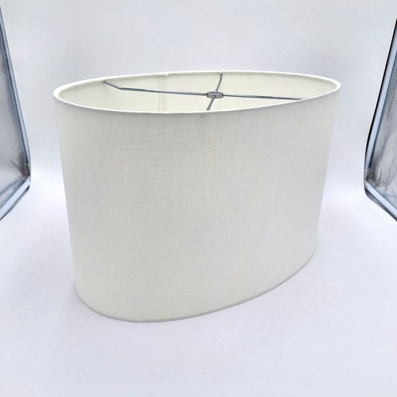A bone linen retro oval lampshade with rolled edges and a translucent finish, shown against a plain white background.