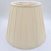 A beige pongee space box pleat empire lampshade shown at a slight angle, highlighting the distinctive spaced pleat design.