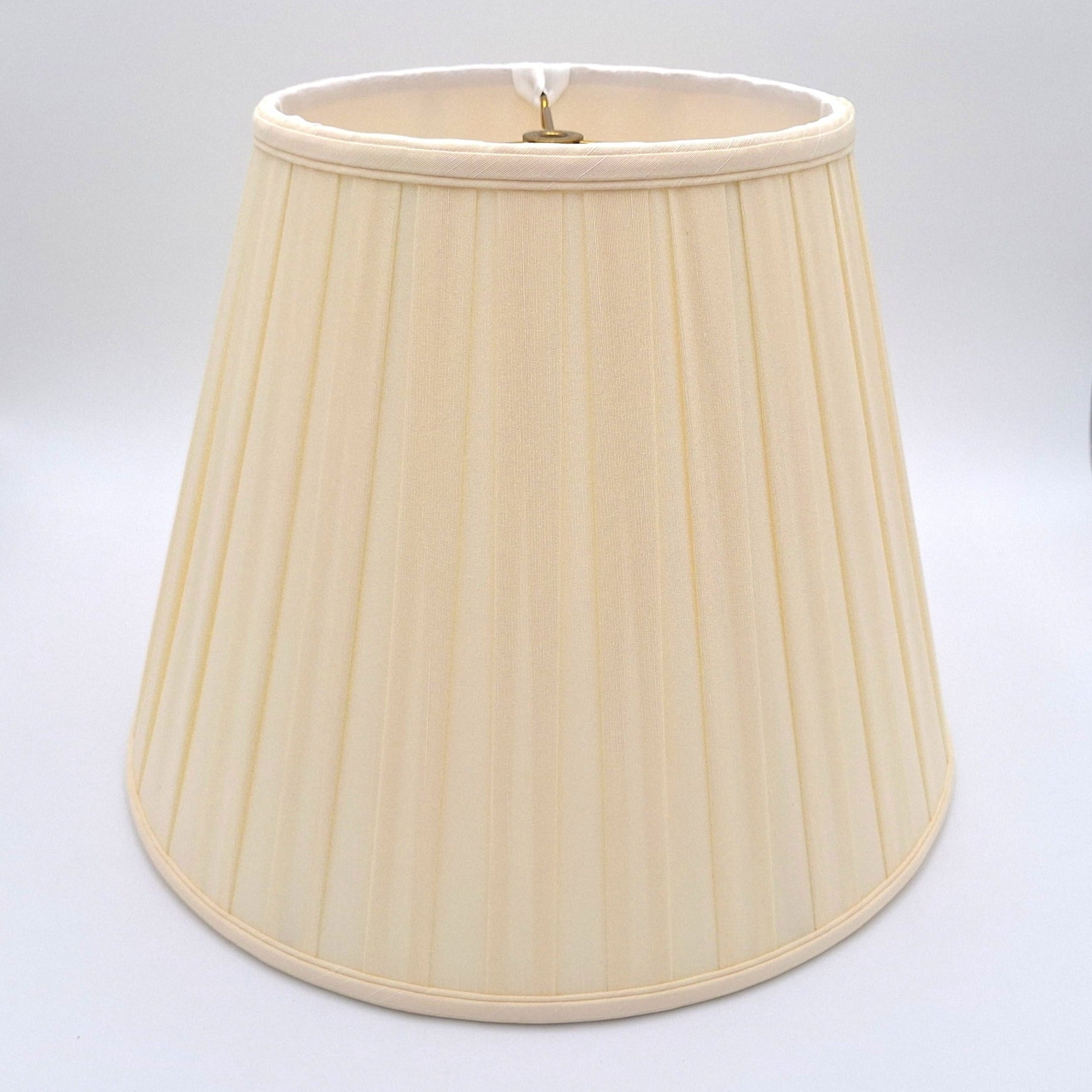 An eggshell shantung space box pleat empire lampshade shown at a slight angle, highlighting the distinctive spaced pleat pattern.