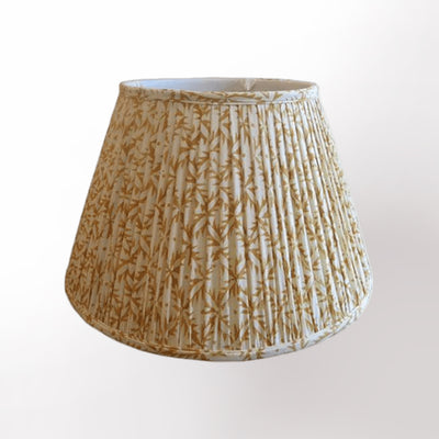 The Sun God Print Shirred Pleat Empire is a modern pleated lamp shade with a yellow and white bamboo leaf pattern, shown on fabric against a plain white background.